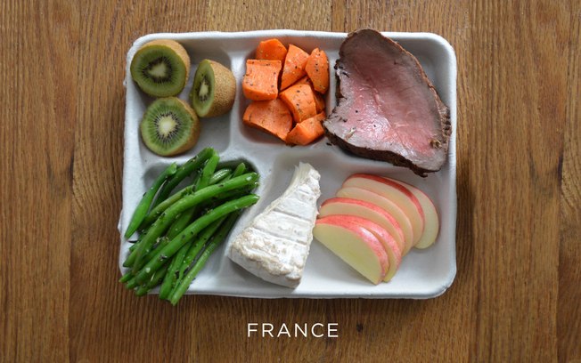 Na França, no cardápio constam um bife, vagem e cenouras cozidas, um pedaço de queijo, pedaços de kiwi e fatias de maça