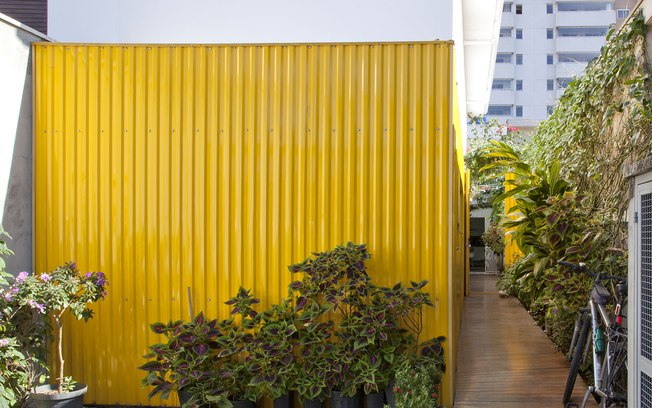 A telha amarela e as plantas espalhadas pela casa dão o tom de férias mesmo dentro da cidade